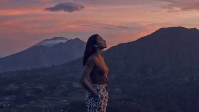 Angela berburu mentari pagi dari celah Gunung Batur di Kintamani (Foto: Instagram/Angela Panari)
