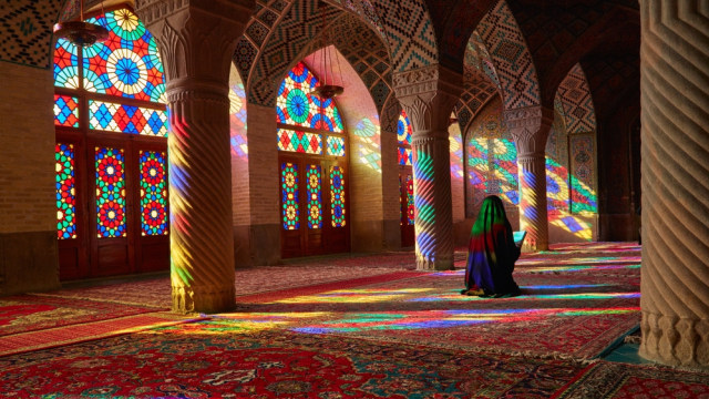 Seorang wanita sedang beribadah di Nasir al-Mulk Mosque di Iran (Foto: Shutter Stock)