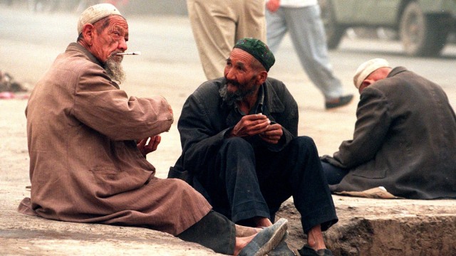Para lelaki lanjut usia Uighur sedang menunggu sedekah di luar pasar di kota Turan, provinsi Xinjiang, China barat laut. (Foto: AFP/Robyn BECK)