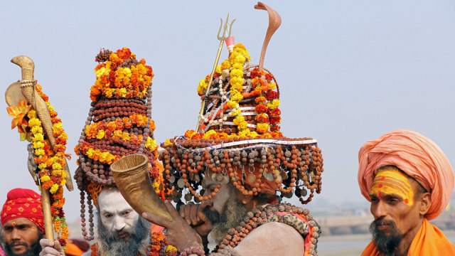 Sadhu (Orang suci Hindu), mengenakan tasbih, memainkan alat musik tradisional di tepi sungai Gangga. (Foto: REUTERS/Jitendra Prakash)