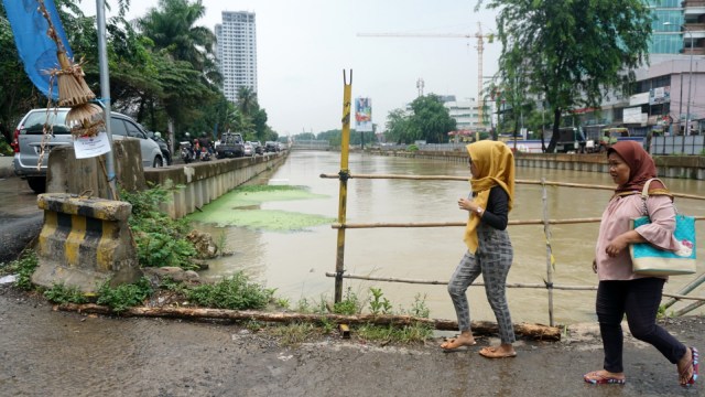 Sejumlah pejalan kaki yang nekat melewati jembatan Haji Santung, Kalimalang, Senin (14/1). (Foto: Iqbal Firdaus/kumparan)