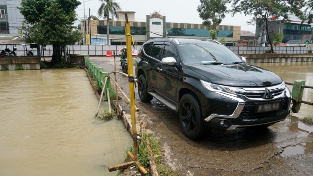 Sejumlah kendaraan yang nekat melewati jembatan Haji Santung, Kalimalang, Senin (14/1). (Foto: Iqbal Firdaus/kumparan)