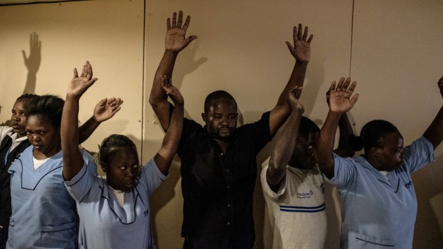 Sejumlah orang menunggu untuk di evakuasi di blok kantor dekat ledakan di komplek hotel Westlands Nairobi, (15/1/19).  (Foto: AFP/KABIR DHANJI)