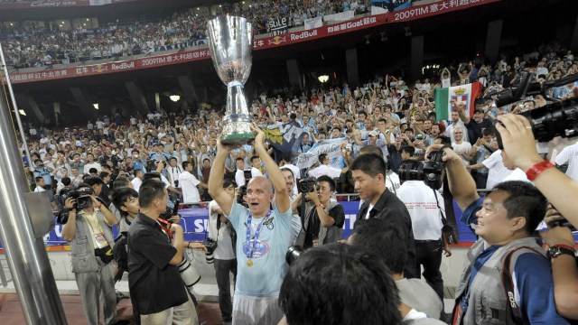Pemain Lazio, Tommaso Rocchi, mengangkat trofi Supercoppa Italiana usai mengalahkan Inter di Beijing. (Foto: AFP/Liu Jin)