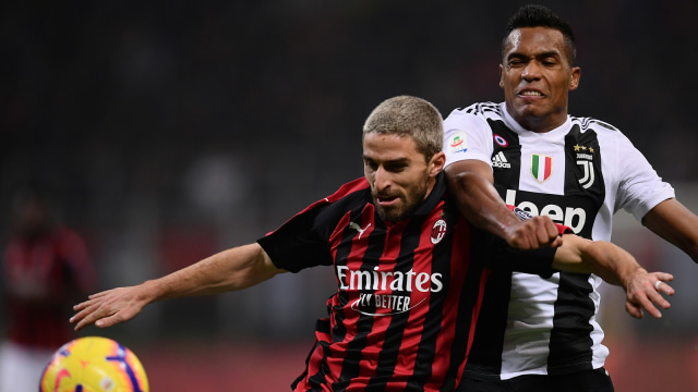 Alex Sandri (kiri) berduel dengan Fabio Borini dalam laga Juventus vs AC Milan. (Foto: Marco Bertorello/AFP)