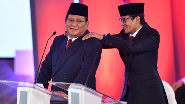 Capres nomor urut 02 Prabowo Subianto (kiri) dipijat pasangan cawapresnya Sandiaga Uno saat jeda Debat Pertama Capres & Cawapres 2019. (Foto: Antara/Sigid Kurniawan)