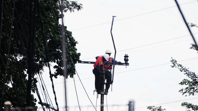 Para pekerja sedang membongkar jaringan listrik udara untuk ditanam ke bawah tanah. (Foto: Helmi Afandi Abdullah/kumparan)