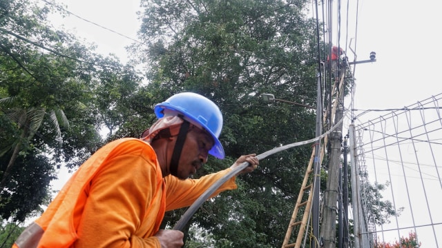 Pekerja sedang menarik kabel listrik dari jaringan listrik udara untuk ditanam ke bawah tanah. (Foto: Helmi Afandi Abdullah/kumparan)