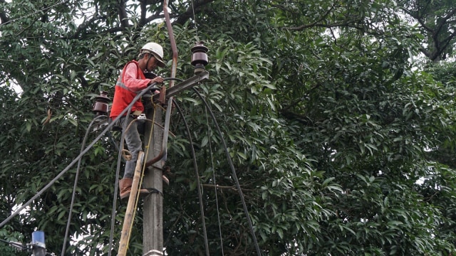 Pekerja sedang membongkar jaringan listrik udara untuk ditanam ke bawah tanah. (Foto: Helmi Afandi Abdullah/kumparan)