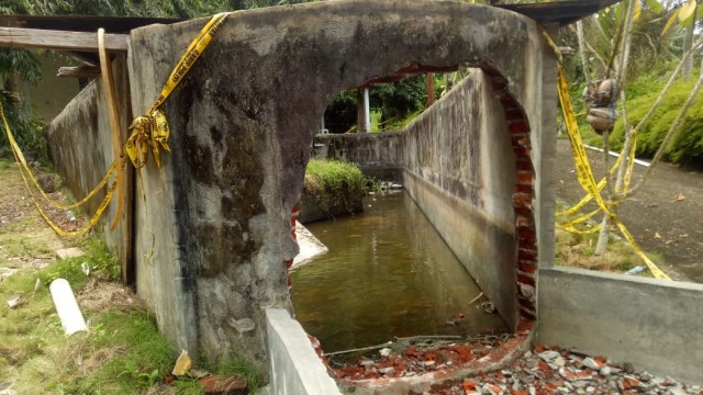 Petugas menjebol tembok penangkaran buaya, lokasi tewasnya Deasy Tuwo di Tanawangko, Sulawesi Utara. (Foto: Andreas Gerry Tuwo/kumparan)