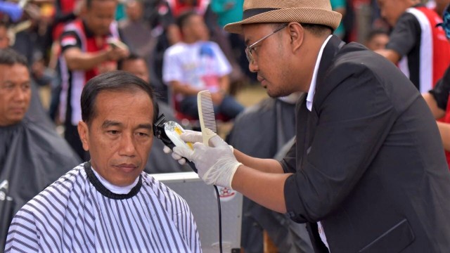 Presiden Joko Widodo saat dipangkas rambutnya oleh Herman, pemuda asal Garut. (Foto: Presidential Palace/Agus Suparto)