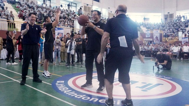 Gubernur DKI Jakarta Anies Baswedan melakukan lemparan bebas pada pembukaan Coaching Clinic Bola Basket NBA Junior Asia DKI Jakarta 2019 di Gedung Olahraga Ciracas, Jakarta, Selasa (22/1). (Foto: Irfan Adi Saputra/kumparan )