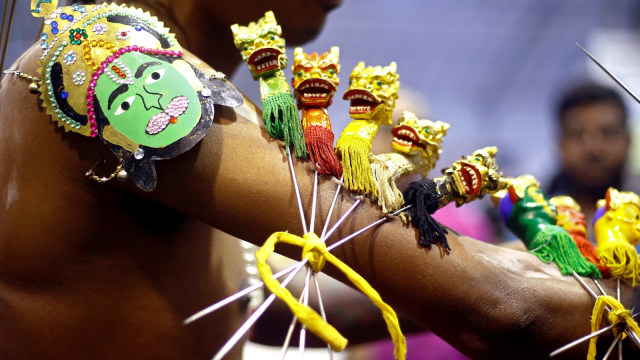 Umat Hindu menindik lengannya saat festival Thaipusam di Singapura. (Foto: REUTERS/Lai Seng Sin)