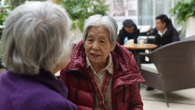 Saat dua orang warga yang telah lanjut usia berbincang-bincang di komunitas Yanyuan, Beijing, China. Foto: AFP/GREG BAKER 