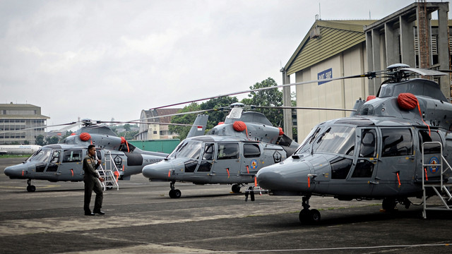 Seorang pilot melintas di antara helikopter AKS saat acara serah terima alutsista di Hanggar PT Dirgantara Indonesia (PTDI), Bandung. (Foto: Antara/Raisan Al Farisi)