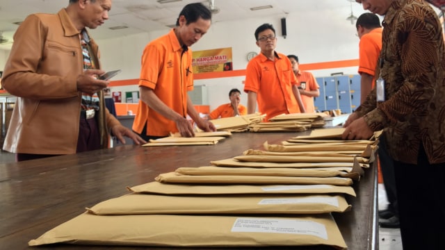 Petugas menahan amplop-amplop yang berisikan Tabloid 'Indonesia Barokah' di Kantor Pos Sentral Pengolahan Pos Yogyakarta, Sleman, DI Yogyakarta,  Kamis (24/1/2019).  (Foto: Arfiansyah Panji Purnandaru/kumparan)