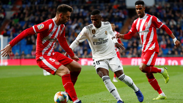 Pemain Madrid, Vinicius Junior, berupaya melepaskan diri dari penjagaan pemain Girona. Foto: REUTERS/Juan Medina