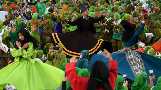 Penari menampilkan Tarian Sufi diantara Muslimat Nahdlatul Ulama (NU) yang menghadiri Harlah ke-73 Muslimat NU di Stadion Utama Gelora Bung Karno, Jakarta, Minggu (27/1).  (Foto: ANTARA FOTO/Wahyu Putro)
