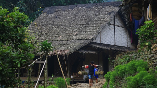 Menggunakan panggul warga membawakan puluhan duren menuju lokasi parkir. (Foto: Aditia Noviansyah/kumparan)