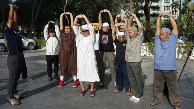 Pimpinan Majelis Azzikra KH Muhammad Arifin Ilham (tengah) berolah raga di depan Apartemen Mansion One Jalan Sultan Ahmad Shah, Persiaran Gurney, Pulau Tikus, George Town, Penang, Malaysia. (Foto: ANTARA FOTO/Agus Setiawan)