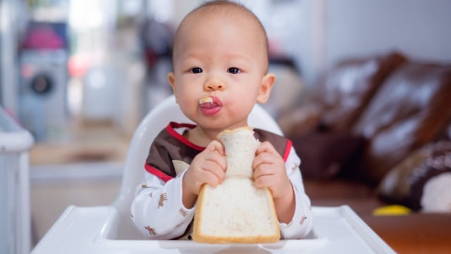 Ilustrasi bayi makan roti. (Foto: Shutterstock)