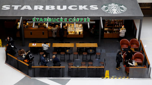 Sejumlah pengunjung saat minum kopi di starbucks. Foto: REUTERS/Thomas Peter