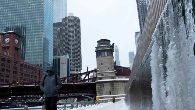 Seorang pria berjalan disebelah sungai Chicago yang membeku akibat pusaran kutub atau polar vortex, Amerika Serikat (29/1/2019). (Foto: REUTERS/Pinar Istek)