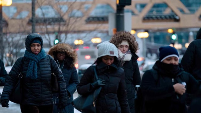 Sejumlah warga berjalan di tengah cuaca yang buruk akibat pusaran kutub atau polar vortex di Chicago, Amerika Serikat (29/1/2019). (Foto: REUTERS/Pinar Istek)
