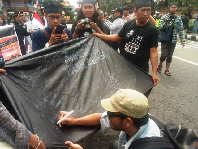 Peserta aksi memberikan tanda-tangan pernyataan keprihatinan atas remisi bagi Susrama (kanalbali/Dok.AJI)
