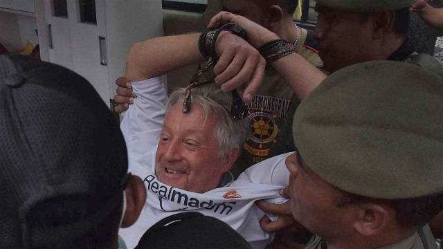 Petugas Satpol PP dan BPBD Kota Denpasar menggiring warga negara Swiss Peter Hugo Rudisuli (tengah) yang mengamuk di Kantor Konsulat Swiss di Denpasar, Bali, Kamis (31/1/2019).  Foto: ANTARA FOTO/Nyoman Hendra Wibowo/nym/aww.