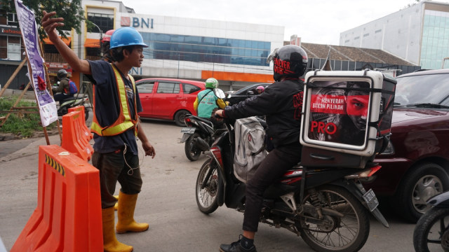 Petugas mengarahkan pengguna jalan imbas dari relokasi Gerbang Tol Cikunir 2. Foto: Iqbal Firdaus/kumparan