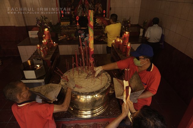 Para pekerja di Wihara Dharma Bakti mencabut hio dari tempatnya, Selasa (5/2/2019). Foto: Fachrul Irwinsyah