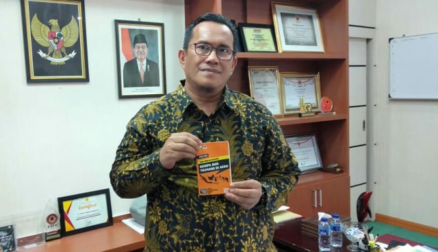 Kepala BPBA, Teuku Ahmad Dadek menunjukkan buku saku panduan manajemen risiko bencana. 