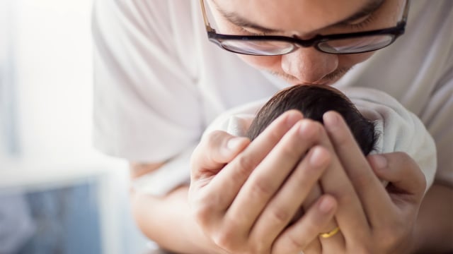Ilustrasi ayah mengadzani bayi baru lahir. Foto: shutterstock