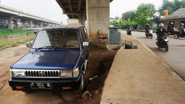 Salah satu mobil yang terparkir di kolong tol di Jalan Inspeksi Saluran Kali Malang, Jakarta Timur. Foto: Iqbal Firdaus/kumparan