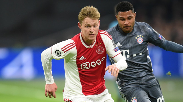 Frenkie de Jong beraksi dengan dibayang-bayangi Serge Gnabry. Foto: AFP/John Thys