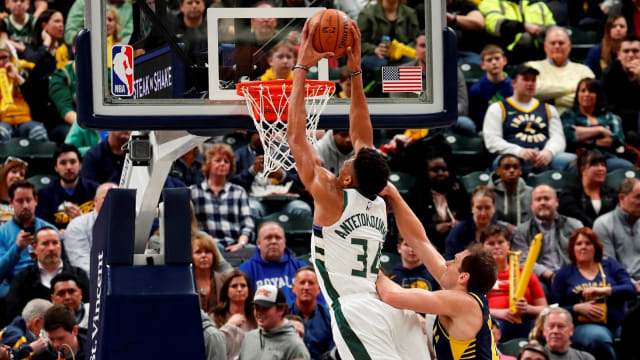 Giannis Antetokounmpo melakukan dunk dengan dibayangi oleh Bojan Bodganovic. Foto: USA Today via Reuters/Brian Spurlock