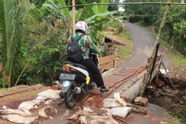 Pengendara motor yang sedang melewati jembatan sementara di Desa Kurungan Nyawa, Pesawaran | foto: Latifah Desti Lustikasari/lampunggeh.co.id