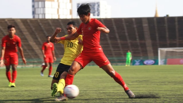 Pemain Timnas U-22 Indonesia, Firza Andika (kanan) berusaha melewati pemain Timnas U-22 Malaysia (Nama) dalam pertandingan Grub B Piala AFF U-22 di Stadion Nasional Olimpiade Phnom Penh, Kamboja, Rabu (20/2). Foto: Aditia Noviansyah/kumparan
