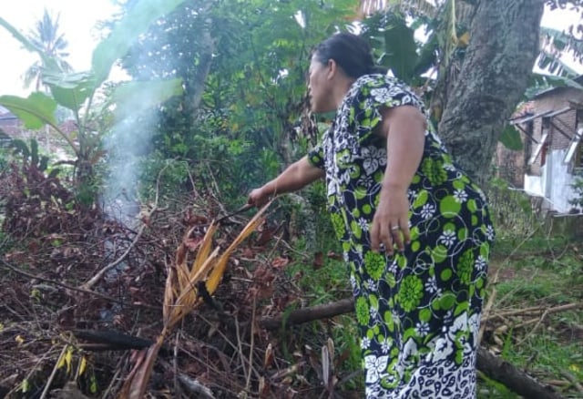 Nila Ariyanti (56) saat membakar sampah | Foto : Latifah Desti Lustikasari/Lampunggeh.co.id