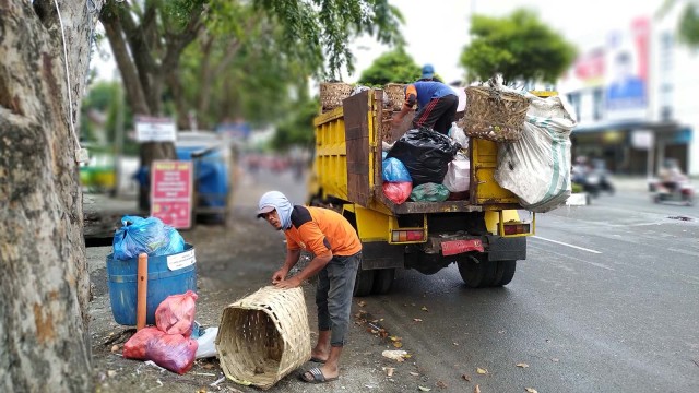 Haikal dan rekannya, petugas kebersihan Kota Banda Aceh keliling untuk mengankut sampah warga ke TPA, Kamis (21/2). Foto: Adi Warsidi/acehkini