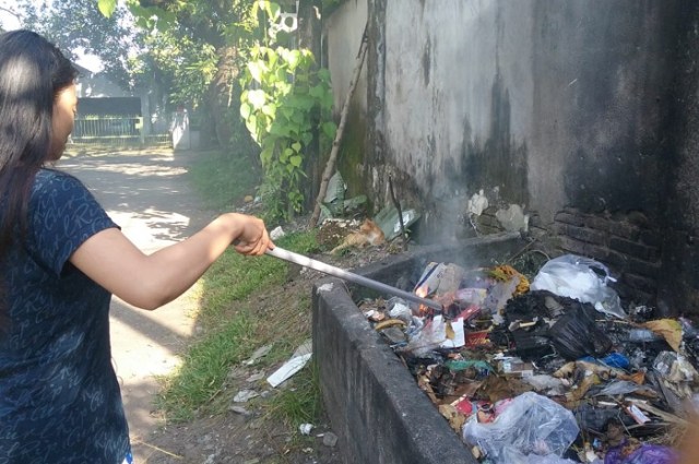 Sartika warga jalan Emmy Saelan sedang membakar sampah (Makassar Indeks).