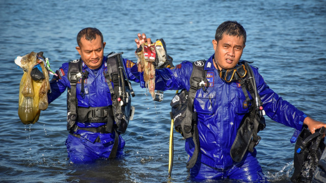 Sejumlah anggota Polair Polda NTB mengangkat sampah dari laut saat aksi bersih pantai di Tanjung Karang, Mataram, NTB, Kamis (21/2). Foto: ANTARA FOTO/Ahmad Subaidi