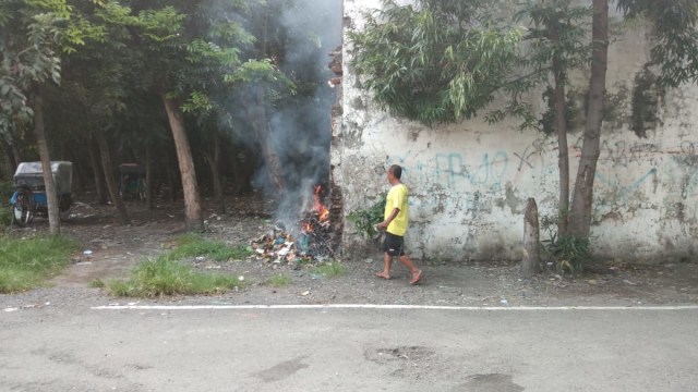 Salah seorang warga Kota Tegal membakar sampah, Rabu (20/2). (Foto: Reza Abineri)