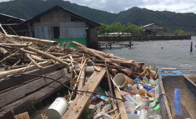 Sampah menumpuk di depan rumah Dikanol Ohee di tempian Danau Sentani. (Foto Katharina)