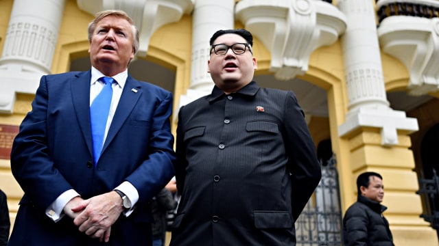 Russel White peniru Presiden AS Donald Trump dan Howard X, peniru pemimpin Korea Utara berfoto di luar gedung opera, Hanoi, Vietnam. Foto: AFP/Manan Vatsyayana
