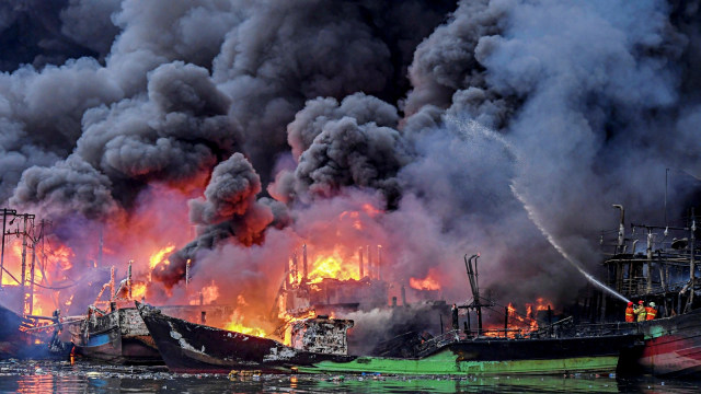 Petugas kebakaran berusaha memadamkan api yang membakar kapal-kapal nelayan di Pelabuhan Muara Baru, Jakarta. Foto: Antara/Hafidz Mubarak A
