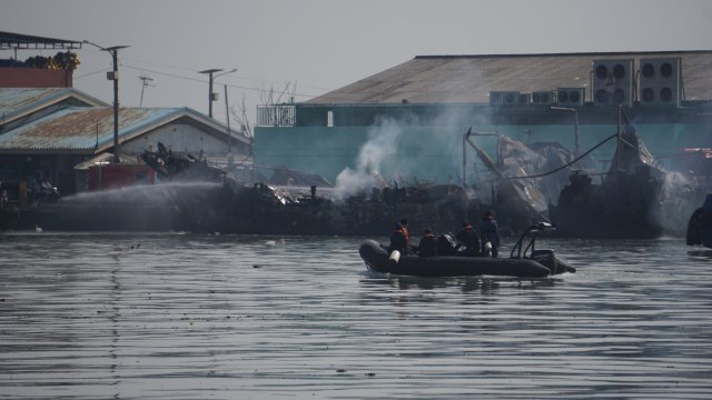 Pendinginan kapal nelayan yang terbakar di Muara Baru, Jakarta, Minggu (24/2/2019). Foto: Jamal Ramadhan/kumparan