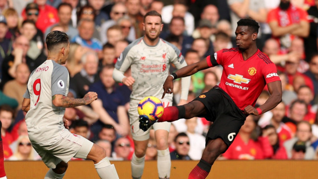 Paul Pogba melindungi bola dari sergapan Bobby Firmino. Foto: Reuters/Lee Smith