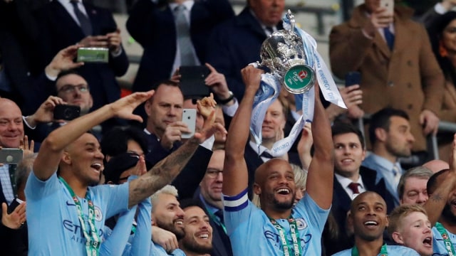 Kapten Man City, Vincent Kompany, mengangkat trofi Piala Liga. Foto: Reuters/David Klein